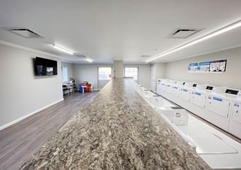A long counter in a room with washers and dryers